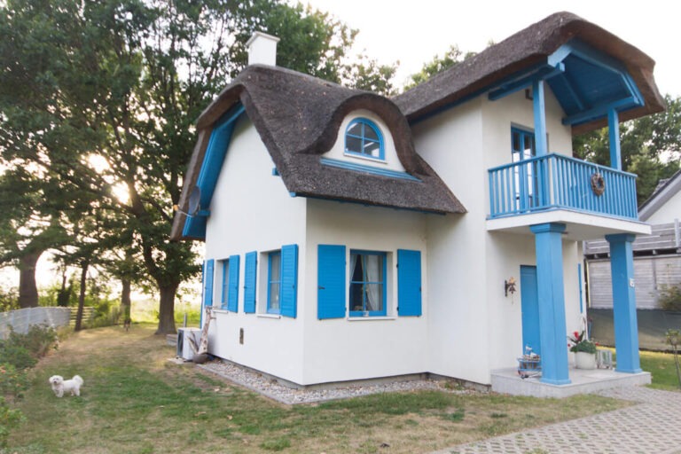 Reetdachhaus am Stettiner Haff, Außenansicht mit Balkon und blauen Fensterläden