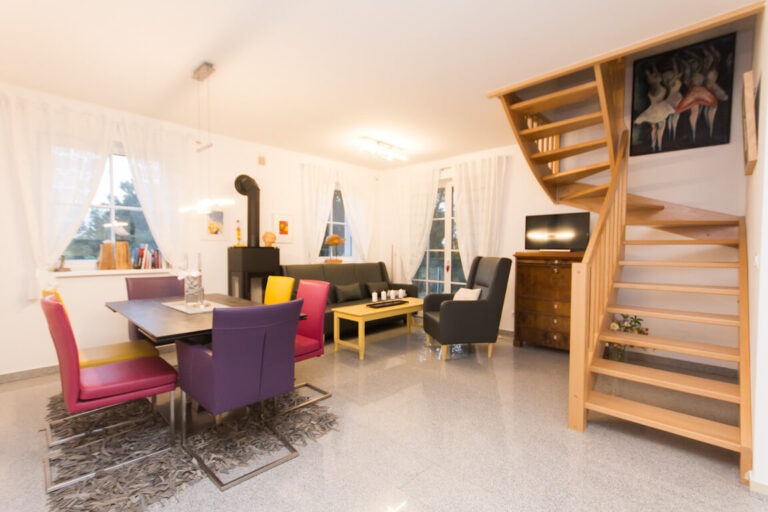 Essbereich mit Kaminofen und Holztreppe im Reetdachhaus