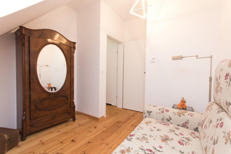 Flur mit Holzschrank und Spiegel im Obergeschoss