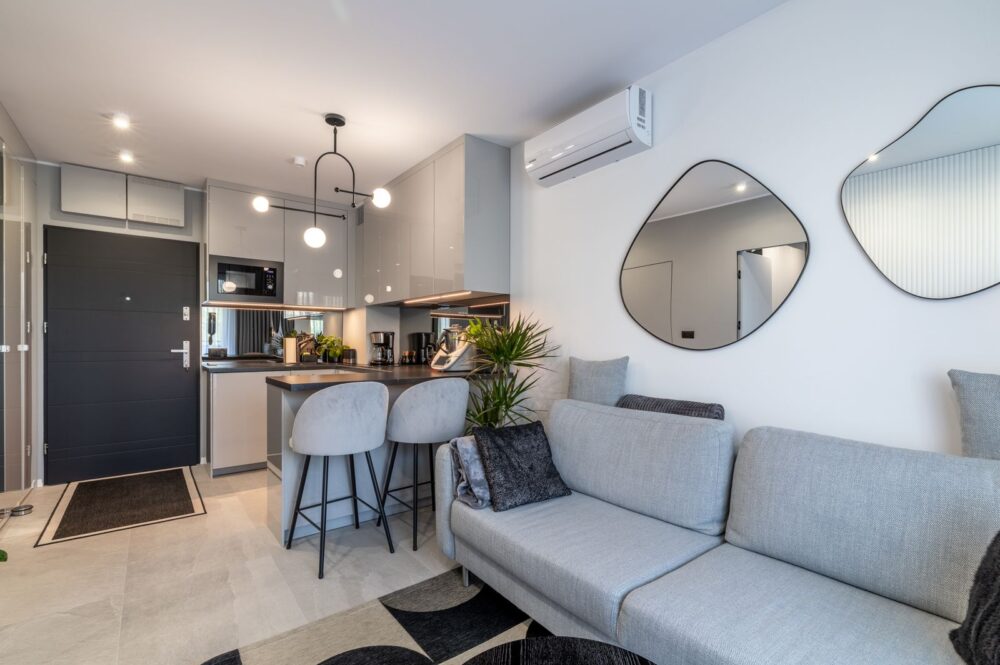 Moderne offene Wohnküche mit Esstisch und Klimaanlage in Wohnung in Swinemünde– Neubau 2024
