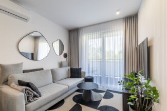 Wohnzimmer mit großer Fensterfront und moderner Einrichtung in Ferienwohnung in Swinemünde